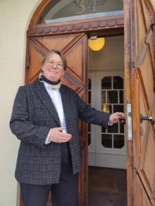 Porträttbild av Annette Johansson vid entrén på kontoret I Halmstad